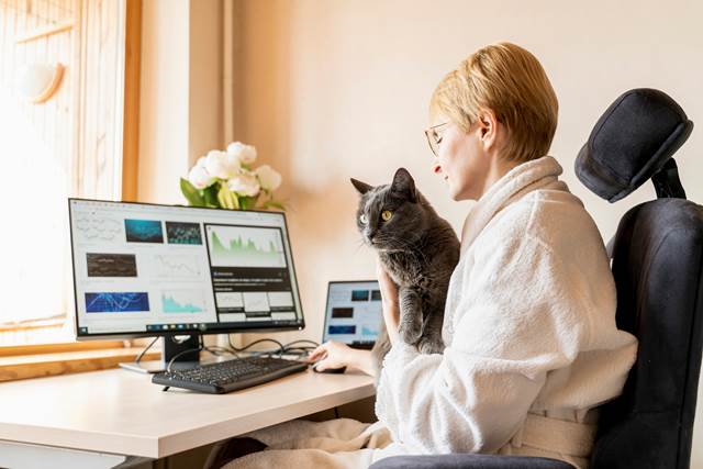 Person working on their computer with cat on their lap